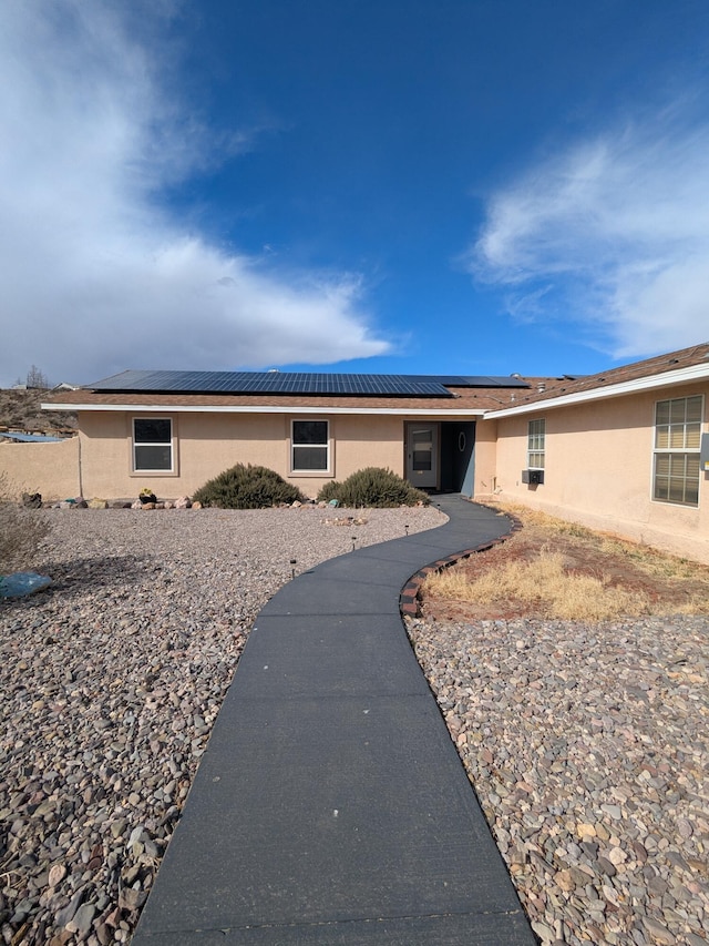 exterior space with solar panels and stucco siding