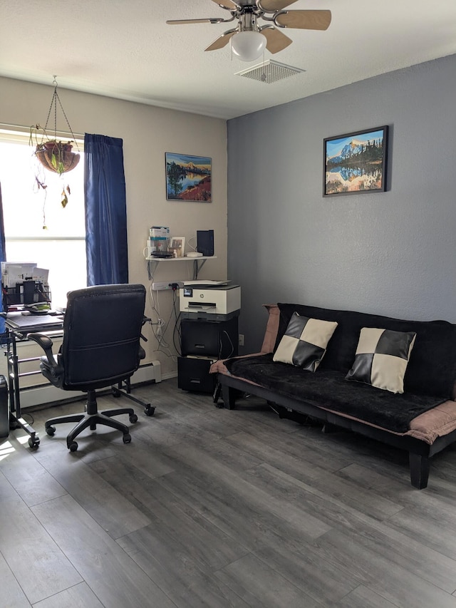 office area featuring visible vents, a ceiling fan, a baseboard radiator, wood finished floors, and a textured ceiling