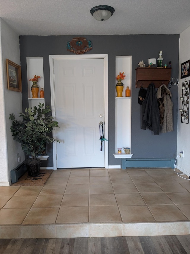 tiled foyer featuring baseboards and baseboard heating