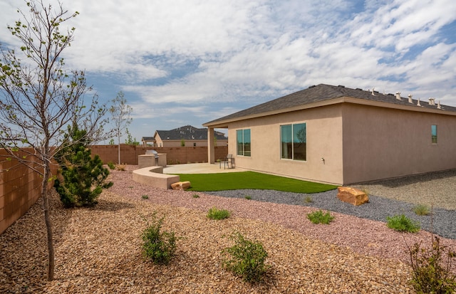 back of house with a patio area, a fenced backyard, and stucco siding