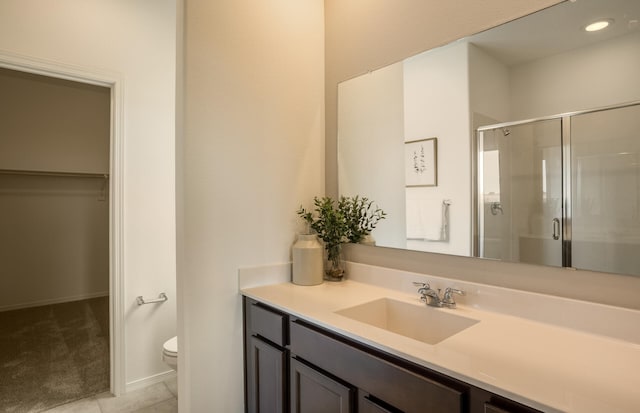 full bathroom with tile patterned flooring, toilet, vanity, a spacious closet, and a stall shower