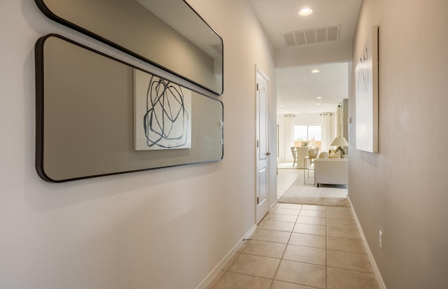 corridor featuring recessed lighting, visible vents, baseboards, and light tile patterned flooring