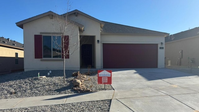 ranch-style home with concrete driveway, an attached garage, and stucco siding