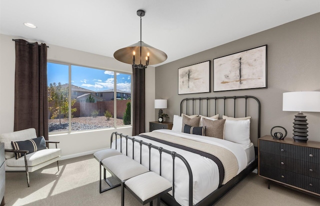 carpeted bedroom featuring an inviting chandelier and baseboards