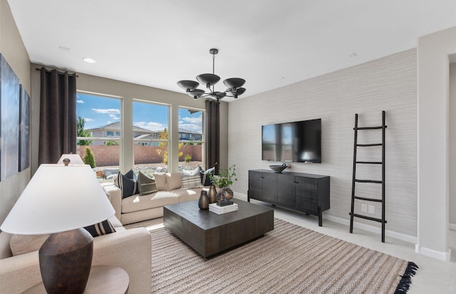 living room featuring wallpapered walls, baseboards, and an inviting chandelier