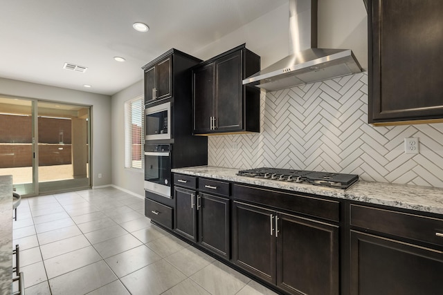 2158 Janet Way, Rio Rancho, NM 87144 - kitchen with appliances with stainless steel finishes, wall chimney exhaust hood, backsplash, light tile patterned floors, and light stone countertops