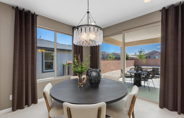 dining room featuring an inviting chandelier and baseboards