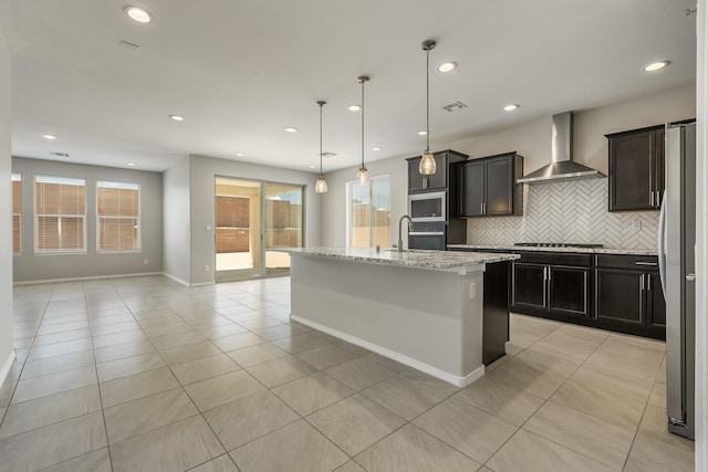 2158 Janet Way, Rio Rancho, NM 87144 - kitchen featuring wall chimney exhaust hood, stainless steel appliances, light tile patterned floors, backsplash, and recessed lighting