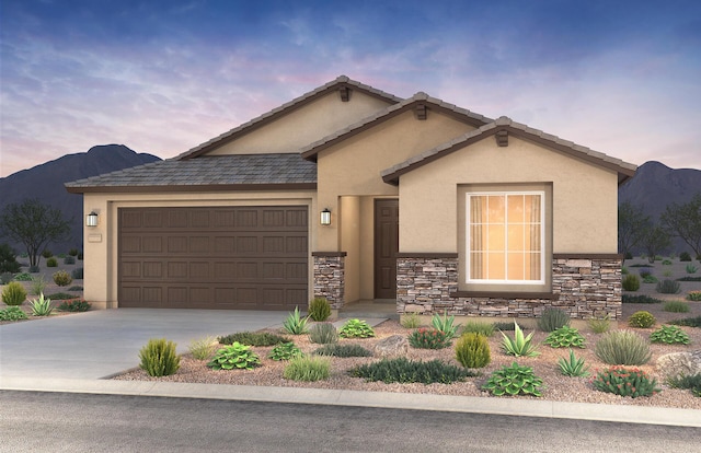 ranch-style home featuring concrete driveway, a mountain view, stone siding, and stucco siding