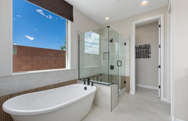 bathroom with a freestanding tub, a stall shower, recessed lighting, tile walls, and tile patterned flooring