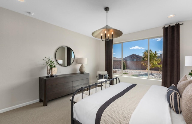 carpeted bedroom with baseboards and a chandelier