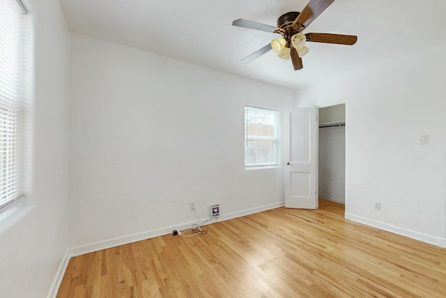 unfurnished bedroom featuring a closet, baseboards, light wood-style flooring, and a ceiling fan