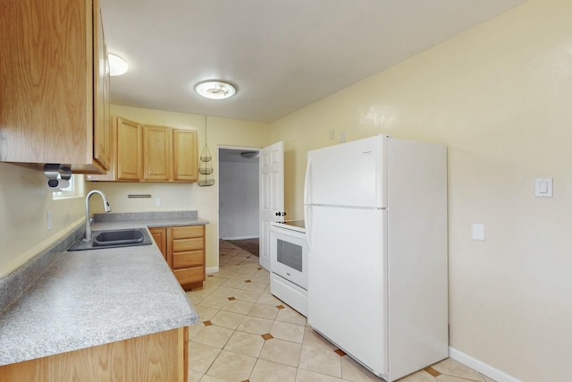 kitchen with light brown cabinets, a sink, white appliances, light countertops, and baseboards