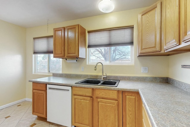 kitchen featuring light countertops, light tile patterned floors, white dishwasher, and a sink