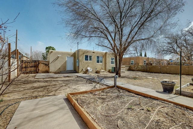 back of property featuring entry steps, a patio, a fenced backyard, and stucco siding