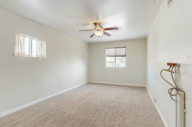 unfurnished room with baseboards, carpet floors, visible vents, and ceiling fan