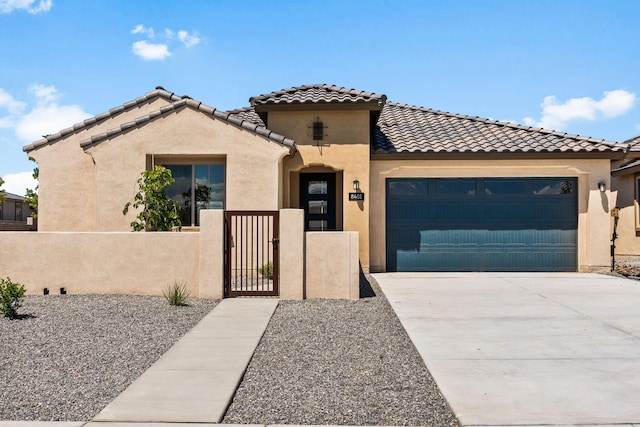 8401 Twain Way NW, Albuquerque, NM 87114 - mediterranean / spanish-style home with a fenced front yard, a garage, stucco siding, driveway, and a gate