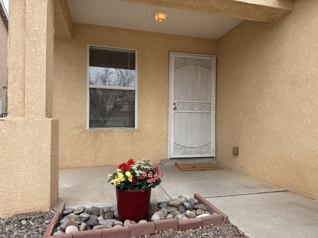 entrance to property featuring stucco siding