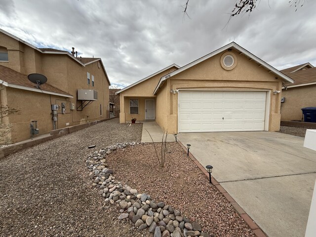 single story home featuring concrete driveway, a garage, and stucco siding