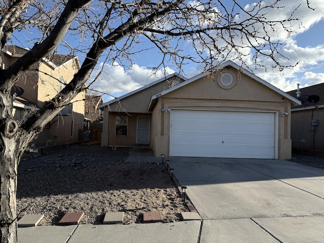 single story home with concrete driveway, a garage, and stucco siding