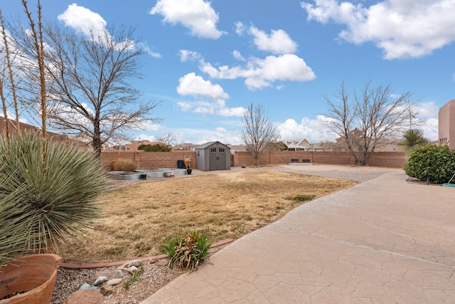 view of yard featuring an outdoor structure, a storage unit, a patio area, and a fenced backyard