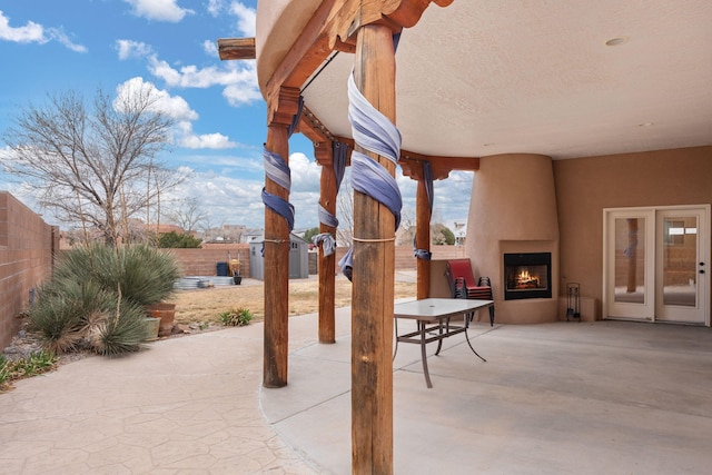 view of patio featuring fence and a large fireplace