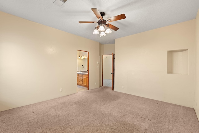 spare room featuring visible vents, light colored carpet, a textured ceiling, and ceiling fan