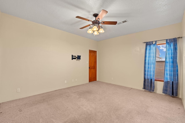 spare room with visible vents, carpet floors, a textured ceiling, and ceiling fan