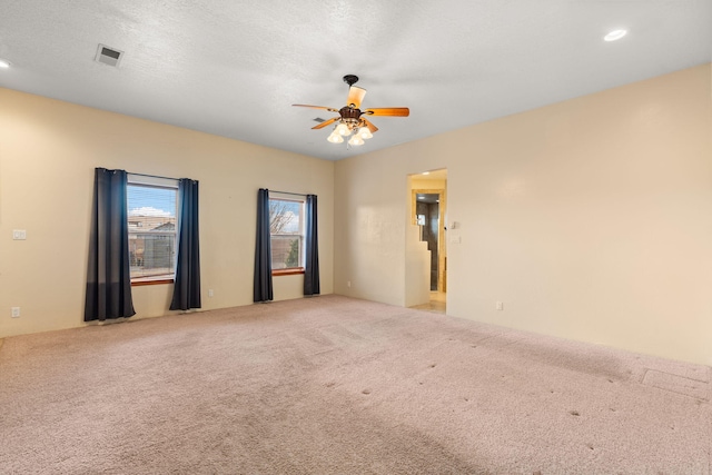 carpeted spare room featuring recessed lighting, visible vents, a textured ceiling, and ceiling fan