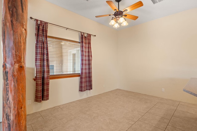 spare room featuring tile patterned flooring, a ceiling fan, and visible vents