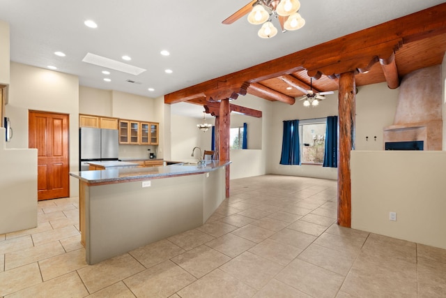 kitchen featuring glass insert cabinets, ceiling fan, beamed ceiling, freestanding refrigerator, and a sink