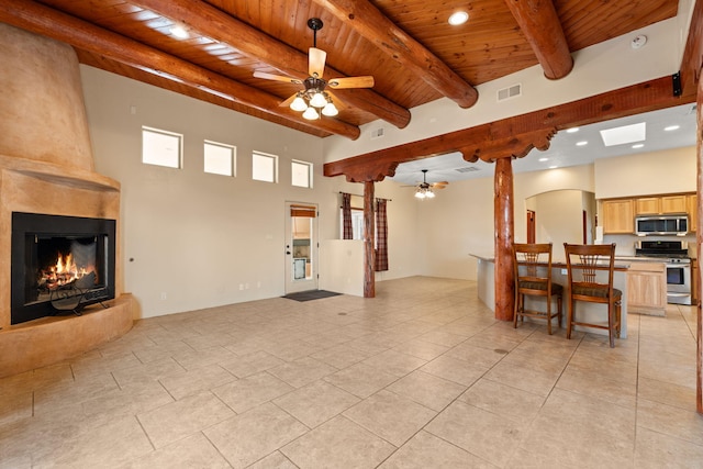 living room with visible vents, ceiling fan, beamed ceiling, wood ceiling, and a fireplace