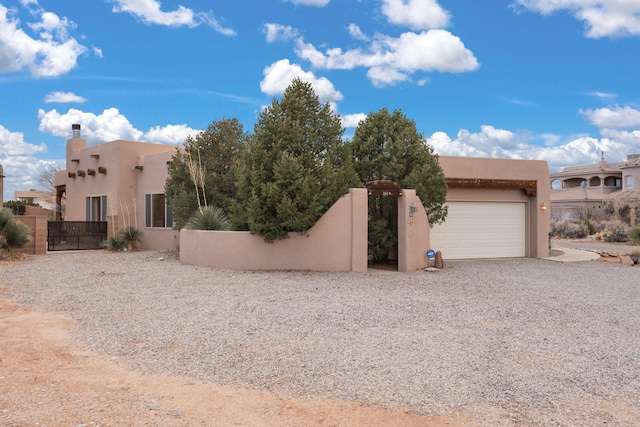 exterior space with stucco siding, fence, and a gate