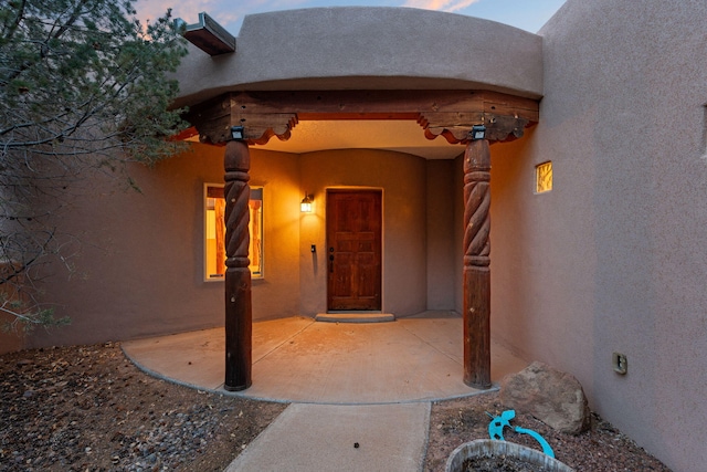 exterior entry at dusk with stucco siding