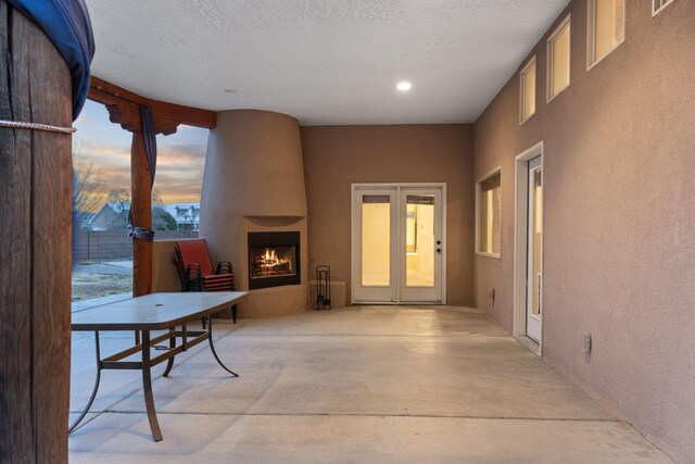 patio terrace at dusk featuring a fireplace