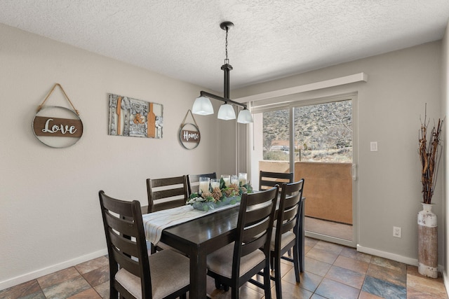 dining room with baseboards and a textured ceiling