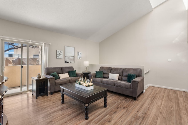 living area with light wood-style flooring, baseboards, and vaulted ceiling