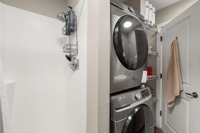 clothes washing area featuring laundry area and stacked washer / dryer