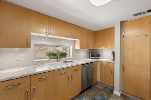 kitchen featuring visible vents, stainless steel appliances, a sink, light countertops, and tasteful backsplash