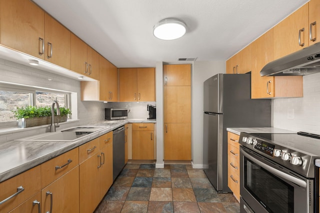 kitchen with visible vents, under cabinet range hood, a sink, tasteful backsplash, and stainless steel appliances