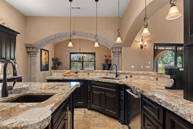 kitchen featuring a sink, light stone counters, and stone tile floors