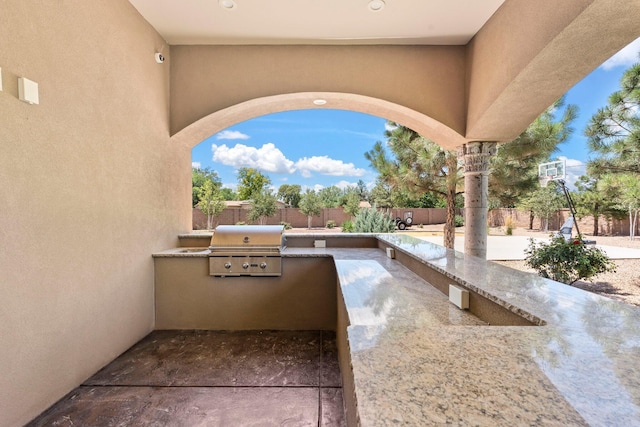 view of patio / terrace featuring grilling area, an outdoor kitchen, and a fenced backyard