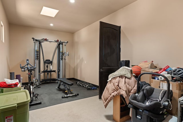 workout area featuring recessed lighting, baseboards, and a skylight