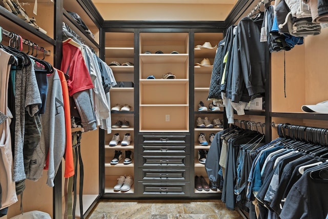 walk in closet with stone finish flooring