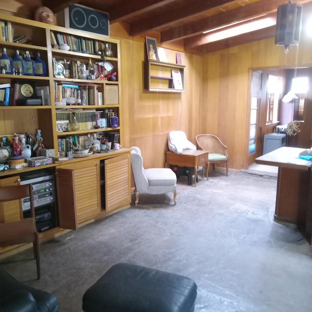 sitting room with beamed ceiling and wood walls