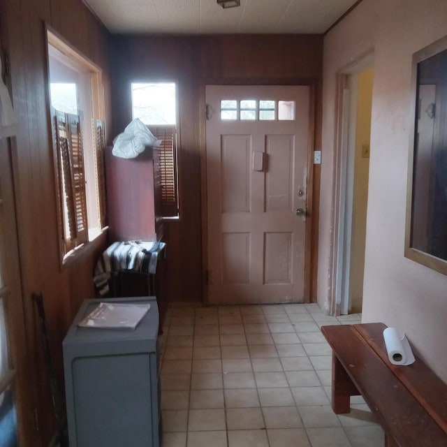 foyer entrance featuring light tile patterned floors and wooden walls