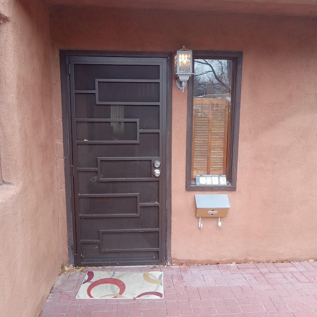 doorway to property featuring stucco siding