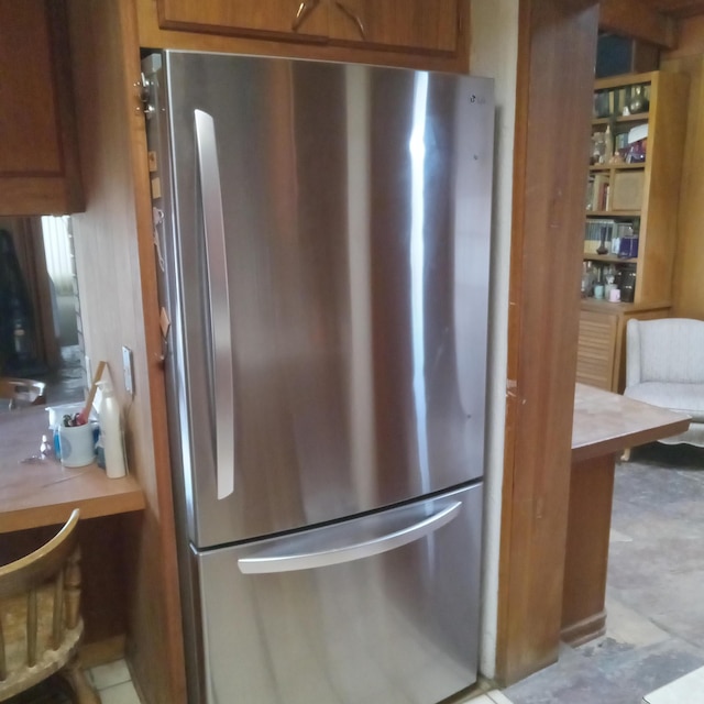 kitchen featuring brown cabinets and freestanding refrigerator