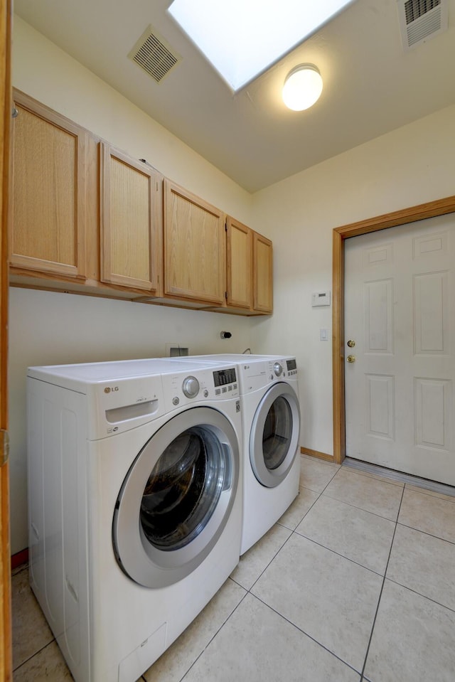 laundry room with light tile patterned floors, cabinet space, visible vents, and washer and clothes dryer