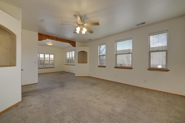 empty room featuring a ceiling fan, visible vents, carpet floors, and baseboards